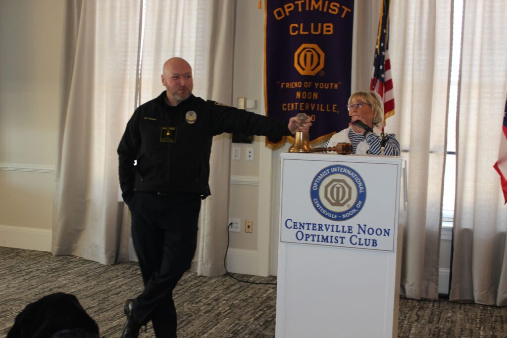 Beth Duncan trying to protect the bell and gavel with police officer Mike Yoder.